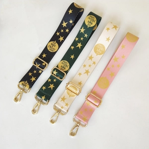 Adjustable woven shoulder straps with gold star patterns and polished metal hardware hooks