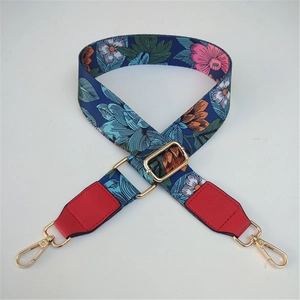 Adjustable floral shoulder strap with dark blue webbing and gold metal swivel hooks