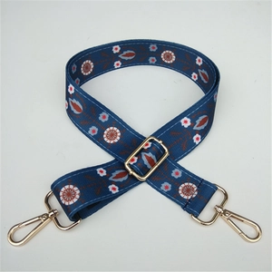 Detail of blue ethnic pattern woven bag strap with adjustable gold metal buckle