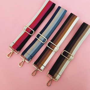 Close-up of colorful striped nylon bag straps with adjustable gold metal hardware buckles
