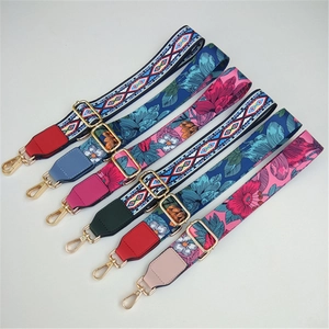 Close-up of adjustable bag straps with bohemian floral patterns and gold metal buckles