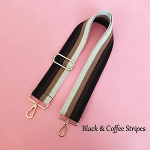 Detail of adjustable black and coffee striped bag strap with gold metal hardware