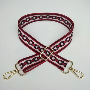 Adjustable wide fabric strap with red and black geometric chain patterns and gold buckles