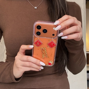 Macro detail of iPhone case with gold leaf, fortune bag and Chinese festive charms