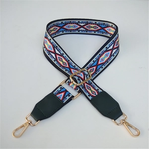 Close-up of adjustable wide woven bag strap with ethnic patterns and gold hardware