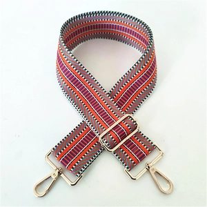 Close-up of ethnic geometric striped woven bag strap with light gold metal swivel hooks