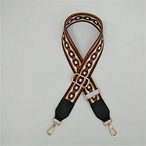 Detail of adjustable woven bag strap with brown chain pattern and gold lobster clasps