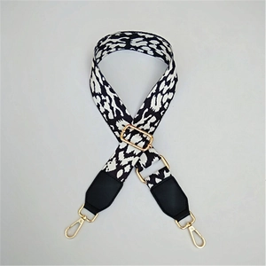 Detail of adjustable leopard print shoulder strap with black leather ends and gold hooks