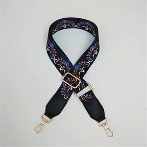 Close-up of adjustable ethnic peacock pattern bag strap with gold metal lobster clasps