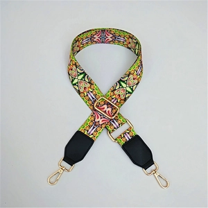 Close-up of geometric pattern strap with gold metal hooks and black leather ends