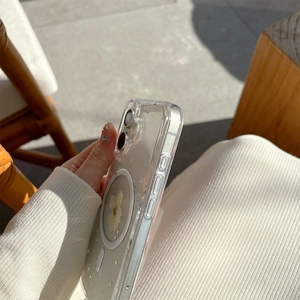 Close-up of clear MagSafe phone case with white dried flowers and colorful glitter