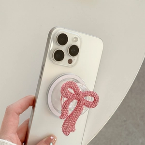Detailed view of a pink rhinestone bow phone grip attached to a smartphone