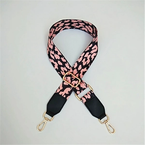 Detail of leopard print bag strap with pink webbing and golden metal buckles
