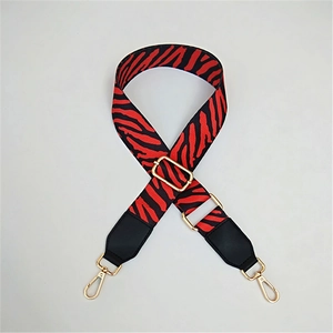 Detail of adjustable zebra pattern shoulder strap with gold-tone hardware for handbags