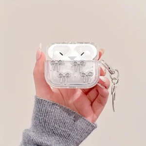 Close-up of clear AirPods case with silver bow charms and a stylish metal snake chain