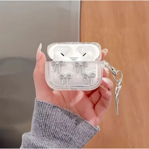 Close-up of clear AirPods Pro case featuring silver bow charms and a metal chain link