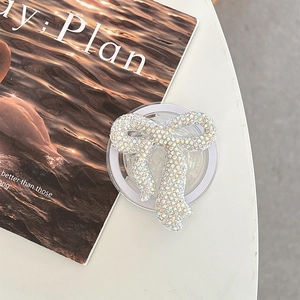 Close-up of sparkling rhinestone bow phone grip holder with crystals on a desk