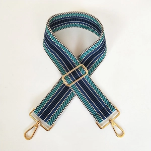 Detail of adjustable blue and green embroidered wide strap with gold metal buckles
