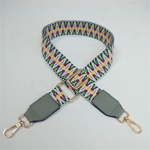 Detail of colorful woven shoulder strap with geometric patterns and golden lobster clasp