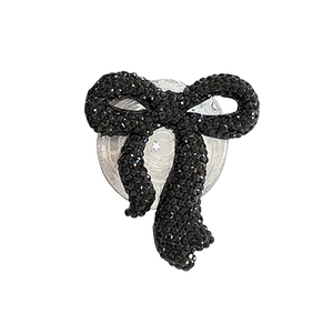 Sparkling black rhinestone bow phone grip with a transparent base on a white background
