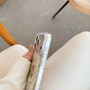 Detail of iPhone case with real dried flowers and pearls embedded in transparent resin