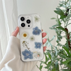 Détails de vraies fleurs bleues pressées et marguerites sur coque iPhone à paillettes