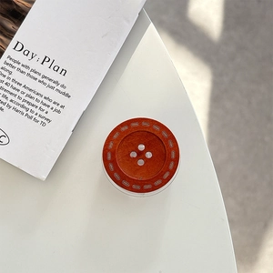 Macro detail of dark brown wood-grain button phone stand with four-hole vintage design