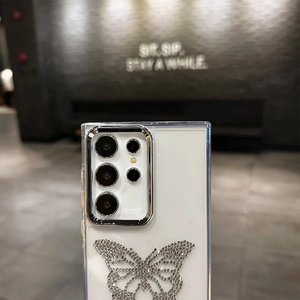 Detail of rhinestone butterfly design and metal camera protection on white phone case
