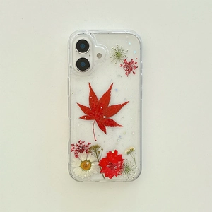Détail d'une vraie feuille d'érable rouge et paillettes de fleurs dans une coque