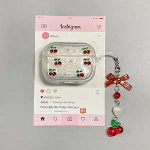 Makroansicht von Strass-Kirsch- und Perlenanhängern an klarer Glitzer AirPods Pro Hülle
