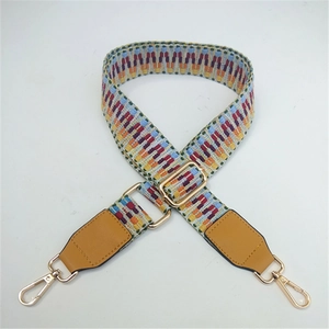 Detail of colorful ethnic woven bag strap with golden metal swivel hooks and adjuster