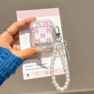 Dettaglio custodia AirPods con fiocchi rosa e una lunga catena di perle elegante