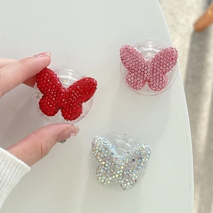 Detailed view of glittering rhinestone butterfly phone socket grips in multiple colors