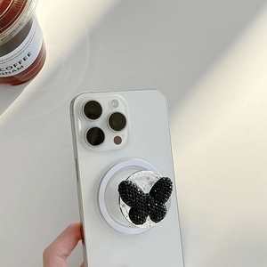 Magnetic cell phone grip with black rhinestone butterfly on a white smartphone