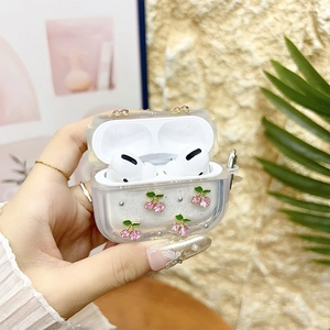 Detail of glitter AirPods Pro case featuring 3D rhinestone cherries and silver bead accents