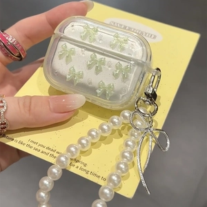 AirPods Pro hoesje met lichtgroene strik en parelketting op een gele achtergrond