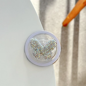 Detail shot of the iridescent crystal butterfly motif on a clear phone grip base
