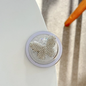 Detailed view of foldable phone grip with sparkling rhinestone butterfly on a purple base