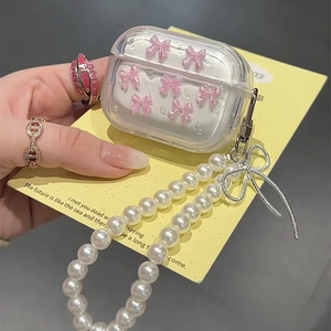 Detail van transparant AirPods hoesje met roze strikjes, parels en een parelketting