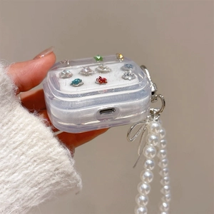 Detail of transparent AirPods case with colorful rhinestones and pearl bow lanyard