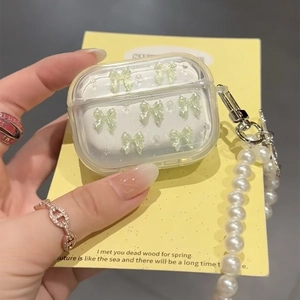 Detail van transparante AirPods Pro hoes met groene strikken en parelketting