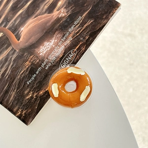 Detailaufnahme einer braunen Handyhalterung in Donut-Form mit weißen Creme-Akzenten
