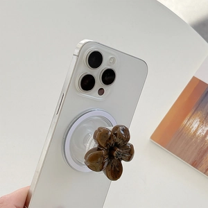 Macro shot of a resin amber flower phone grip attached to a smartphone via MagSafe magnet
