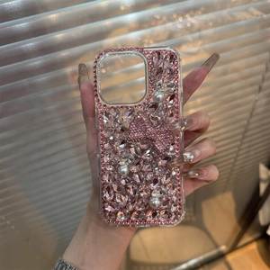 Detailed close-up of luxury phone case featuring pink rhinestones and a large crystal bow