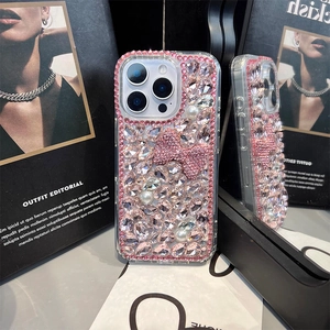Detailed view of luxury iPhone case featuring pink rhinestones and pearl bow decoration