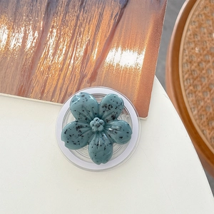 Top view of floral phone socket with retro teal finish and black speckle texture detail