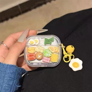 Detail of transparent AirPods case with 3D miniature food charms and egg pendant