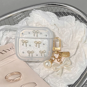 Detailed view of clear glitter AirPods case with pearl and bow pendant on metal mesh