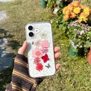 Close-up of glitter phone case with real dried flowers and butterfly under natural light