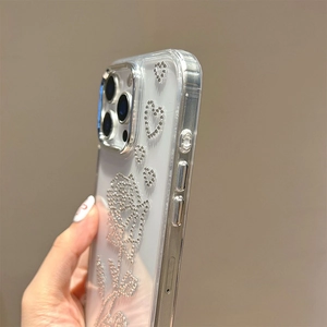 Dettaglio di rosa in strass scintillanti e motivi a cuore su una cover iPhone trasparente